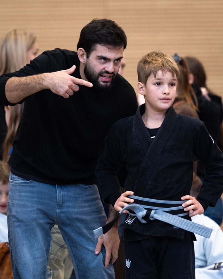 Coach gibt einem Kind letzte Tipps beim Wettkampf. Foto: Photo Blackbelt.