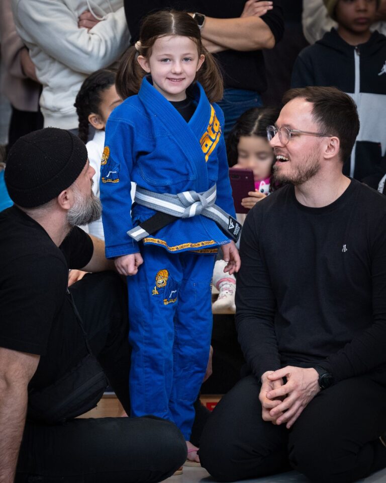 Strahlendes Mädchen im Gi vor ihrem Kampf beim Kinderturnier in Berlin. Foto: Photo Blackbelt.